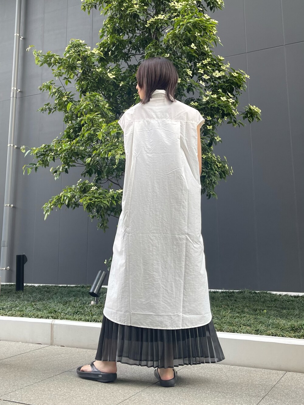 ホワイト系のワンピース、ブラック系のスカートを着用したレディースの夏コーディネートの4枚目の写真