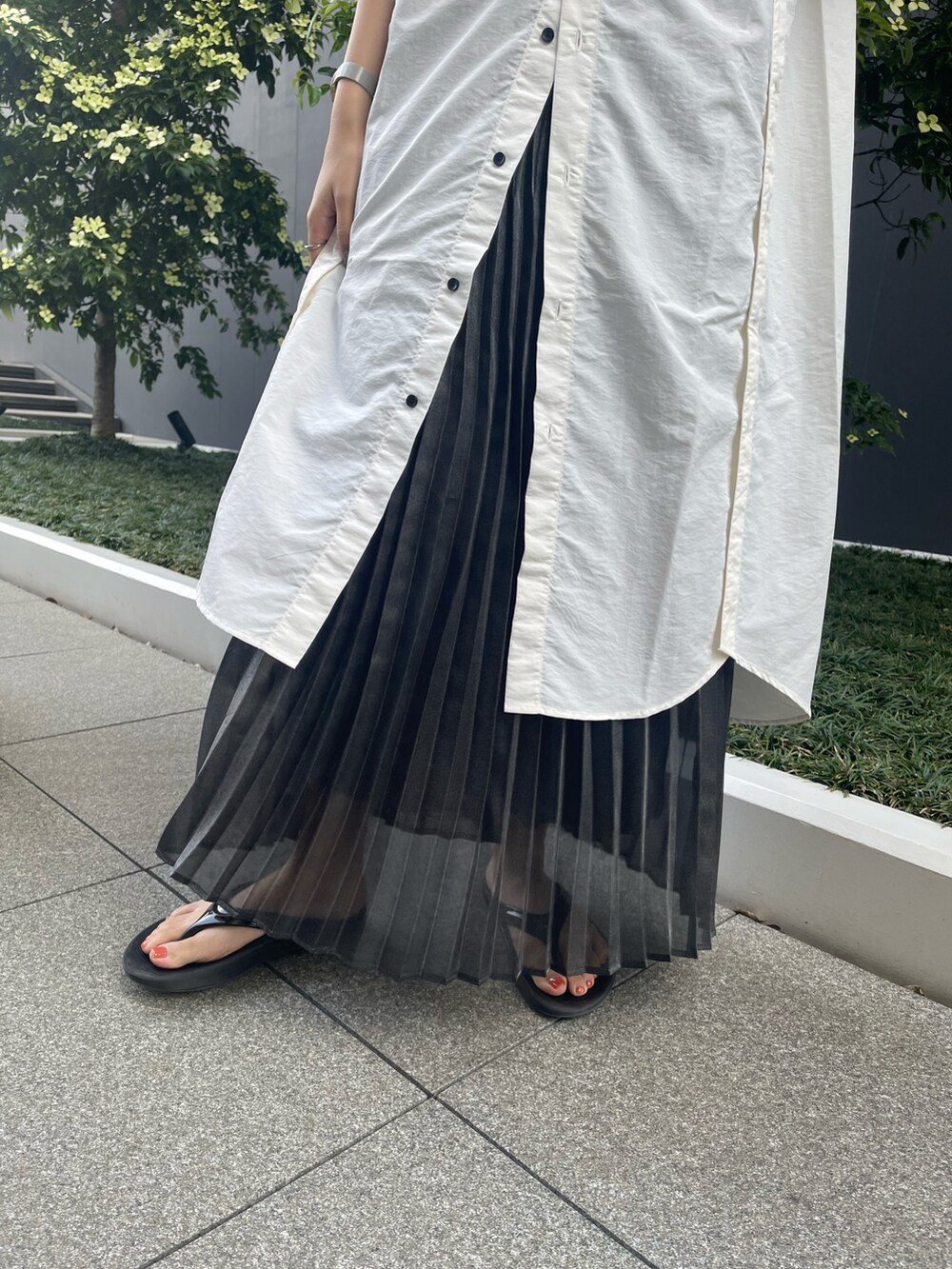ホワイト系のワンピース、ブラック系のスカートを着用したレディースの夏コーディネートの5枚目の写真