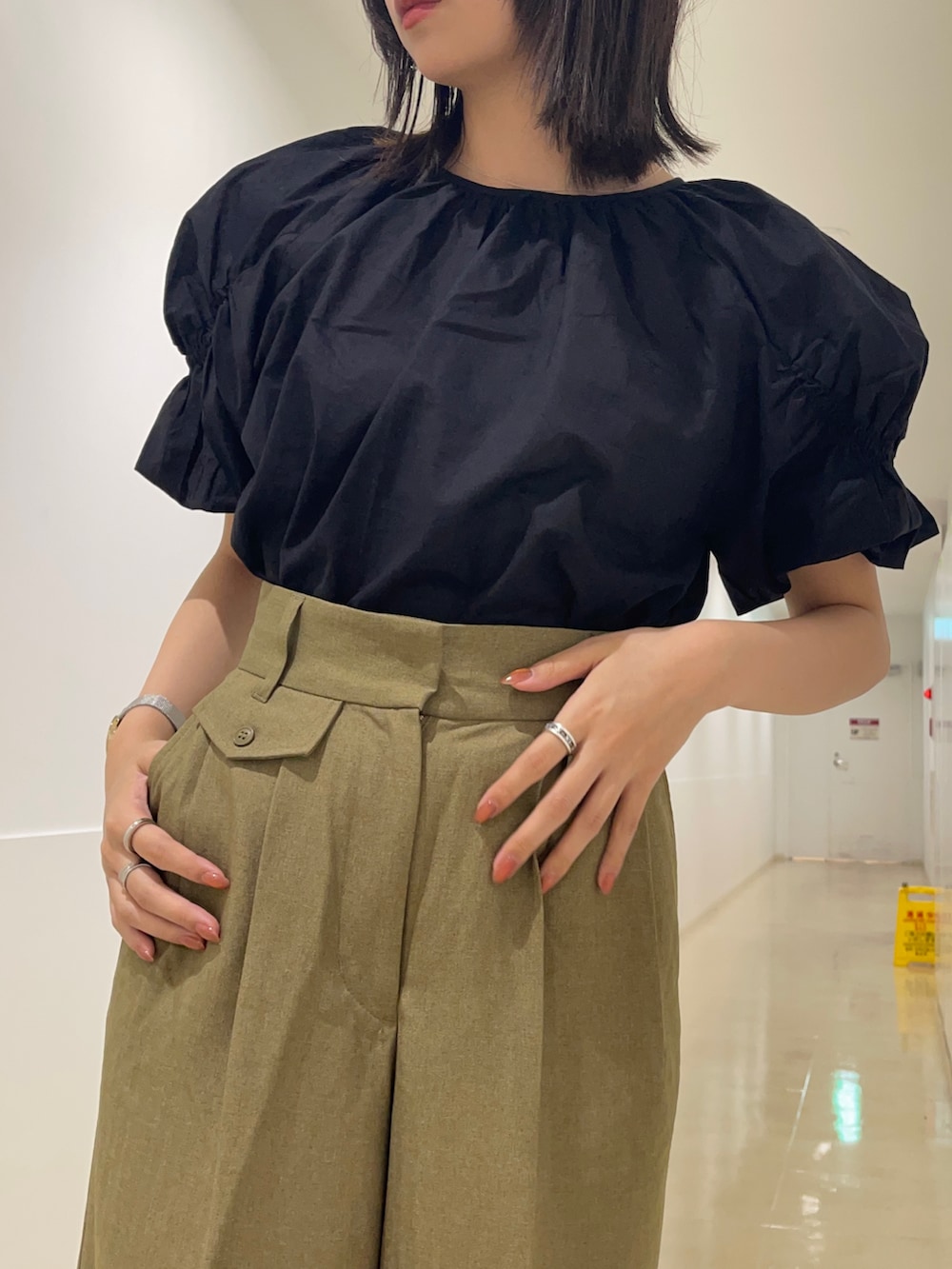 ブラック系のシャツ/ブラウス、グリーン系のその他パンツ、ブラック系のスニーカーを着用したレディースの春コーディネートの5枚目の写真