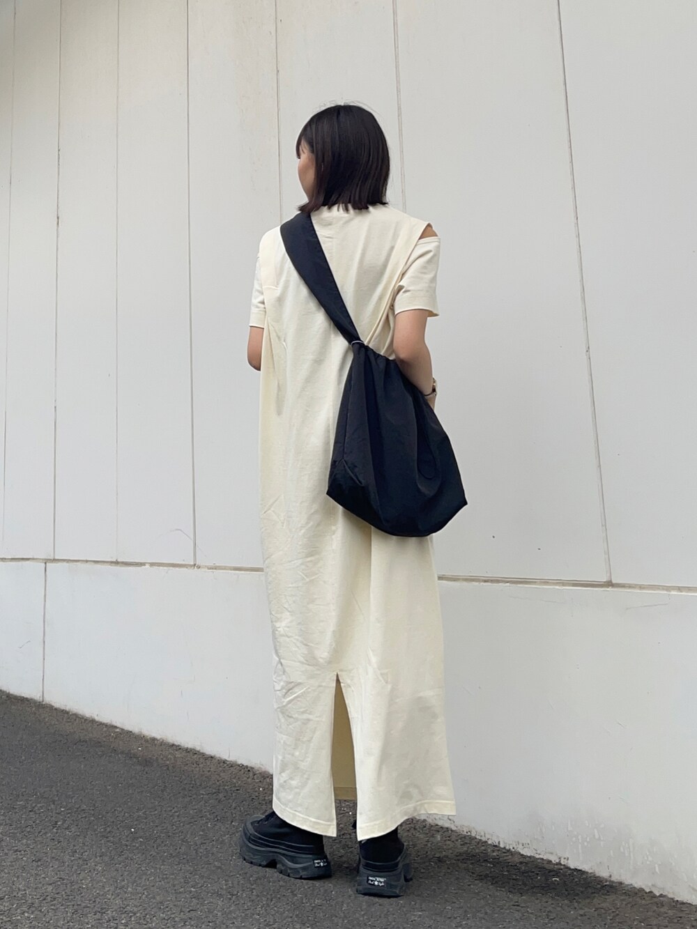 ブラック系のショルダーバッグ、ホワイト系のワンピースを着用したレディースの夏コーディネートの4枚目の写真
