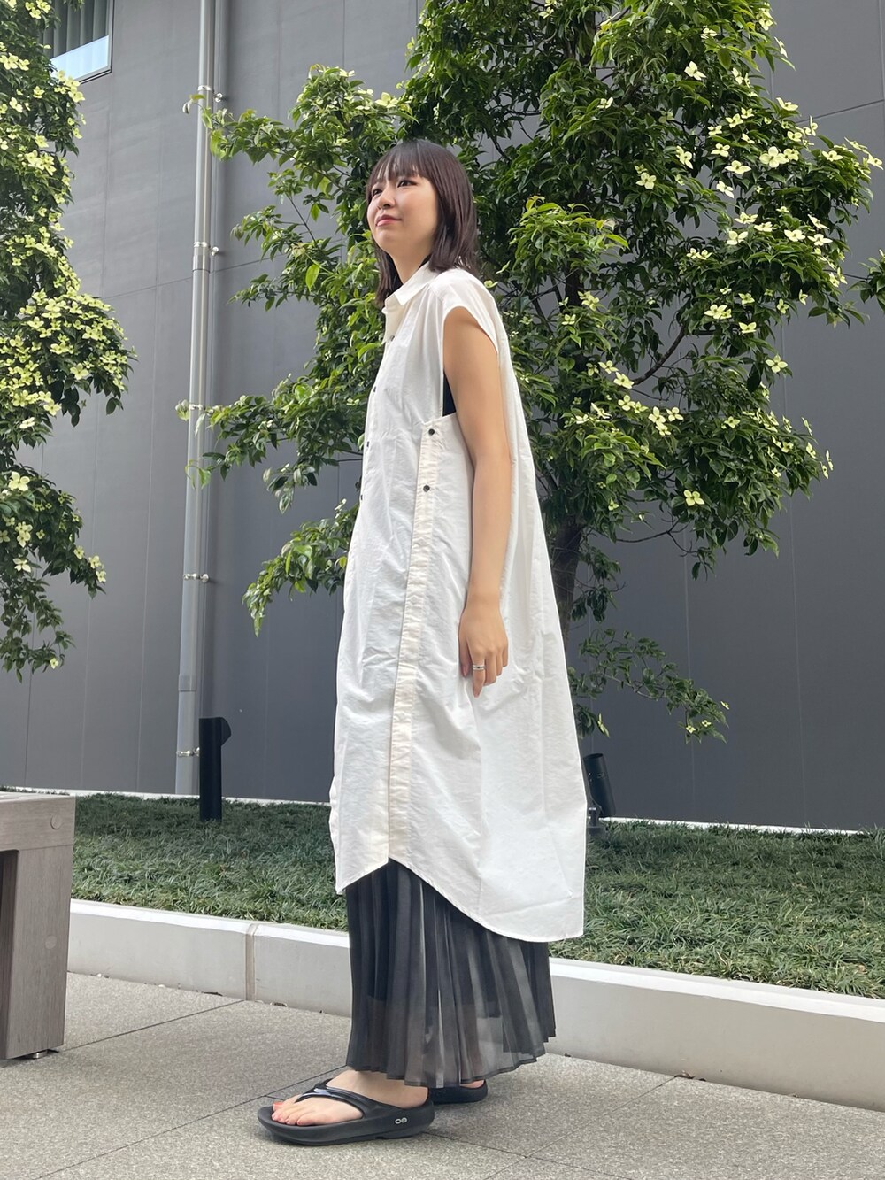 ホワイト系のワンピース、ブラック系のスカートを着用したレディースの夏コーディネートの3枚目の写真