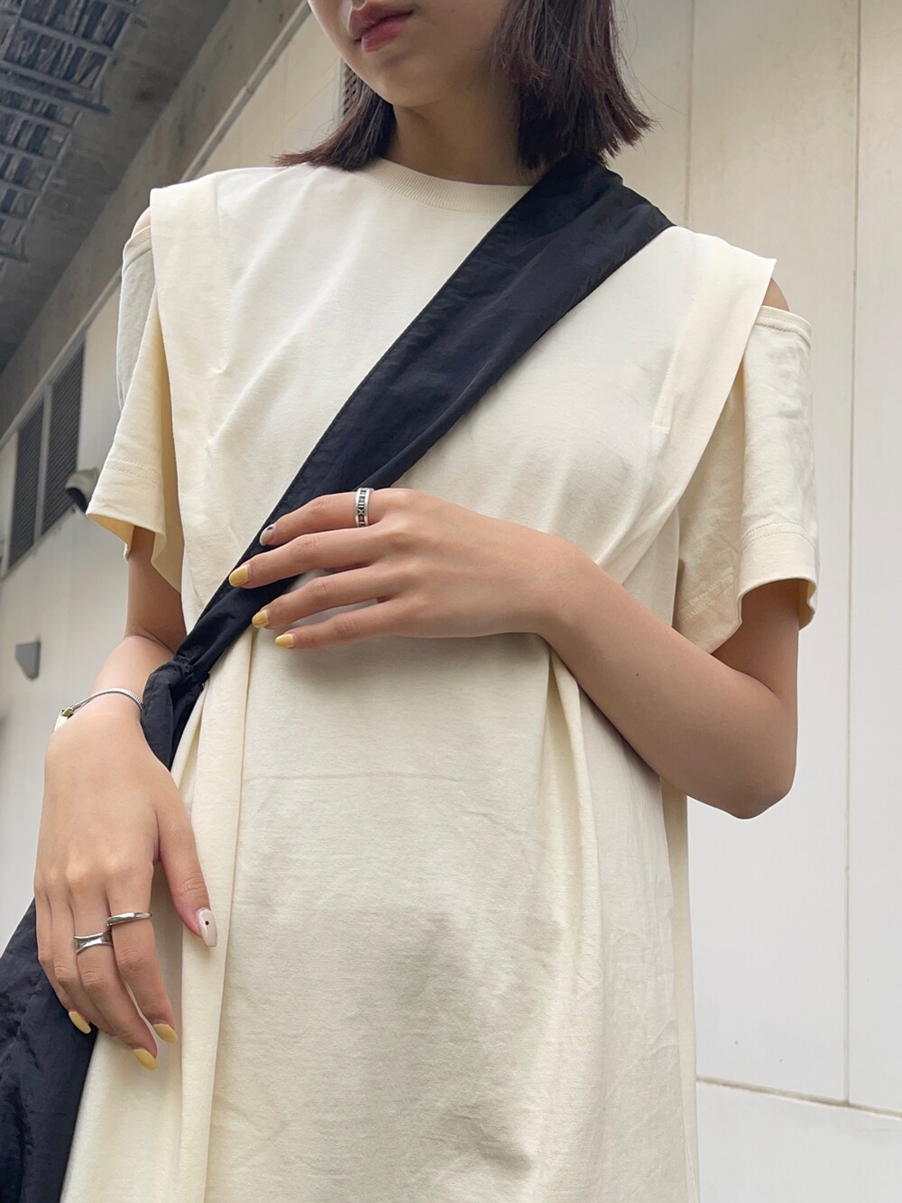 ブラック系のショルダーバッグ、ホワイト系のワンピースを着用したレディースの夏コーディネートの5枚目の写真