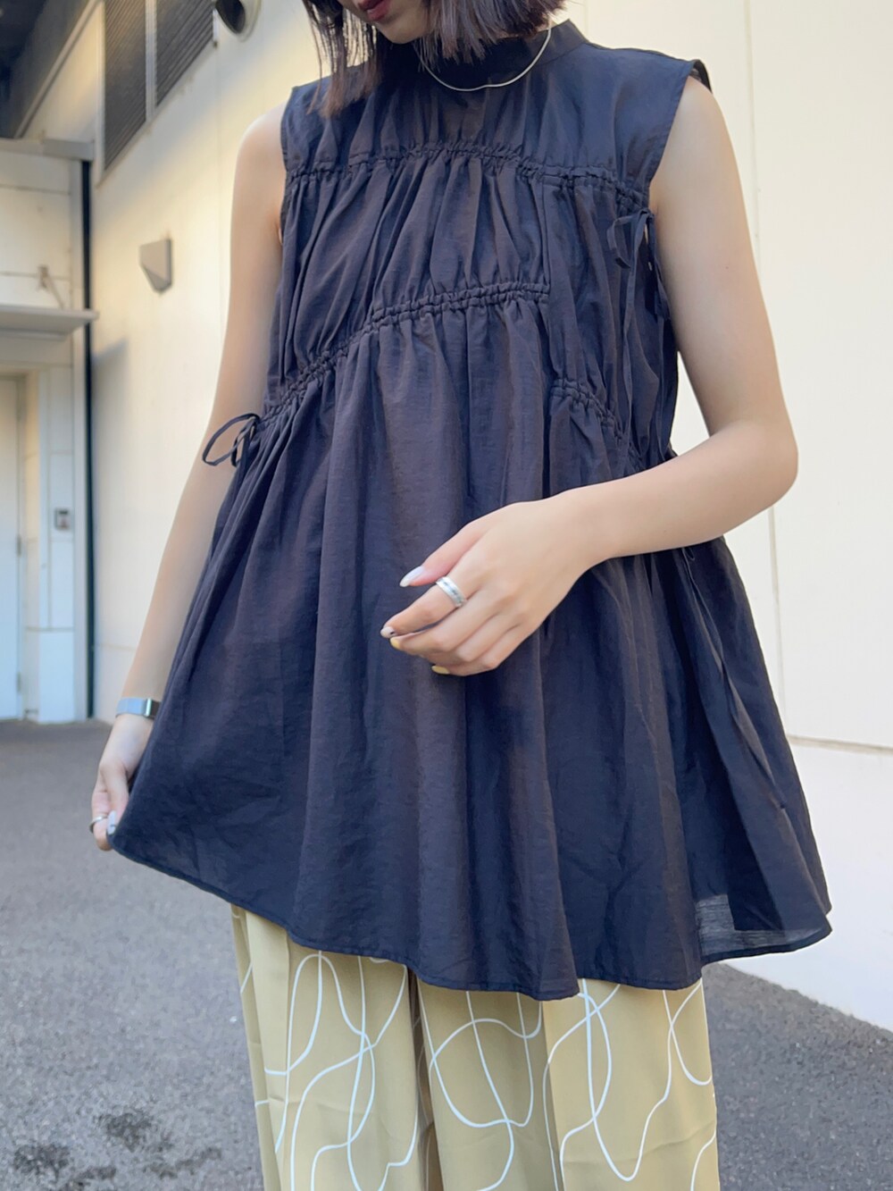 ブラック系のシャツ/ブラウス、ベージュ系のその他パンツ、ホワイト系のサンダルを着用したレディースの夏コーディネートの5枚目の写真