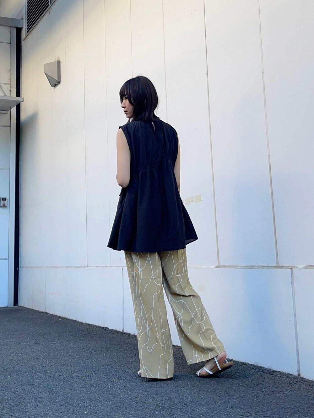 ブラック系のシャツ/ブラウス、ベージュ系のその他パンツ、ホワイト系のサンダルを着用したレディースの夏コーディネートの3枚目の写真