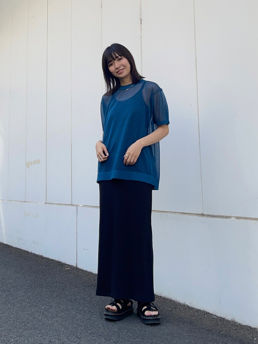 ブラック系のワンピース、ブルー系のニット/セーター、シルバー系のネックレスを着用したレディースの春コーディネートの2枚目の写真