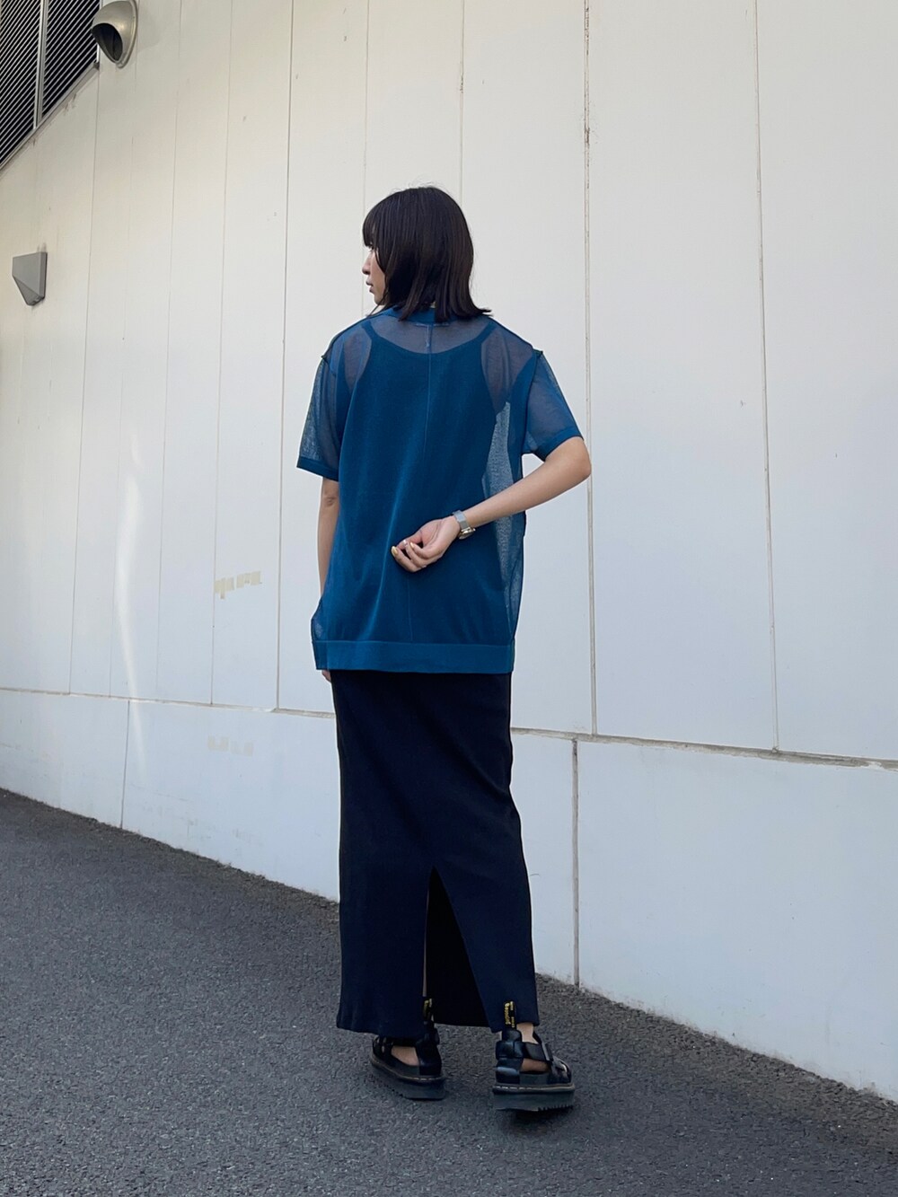 ブラック系のワンピース、ブルー系のニット/セーター、シルバー系のネックレスを着用したレディースの春コーディネートの3枚目の写真