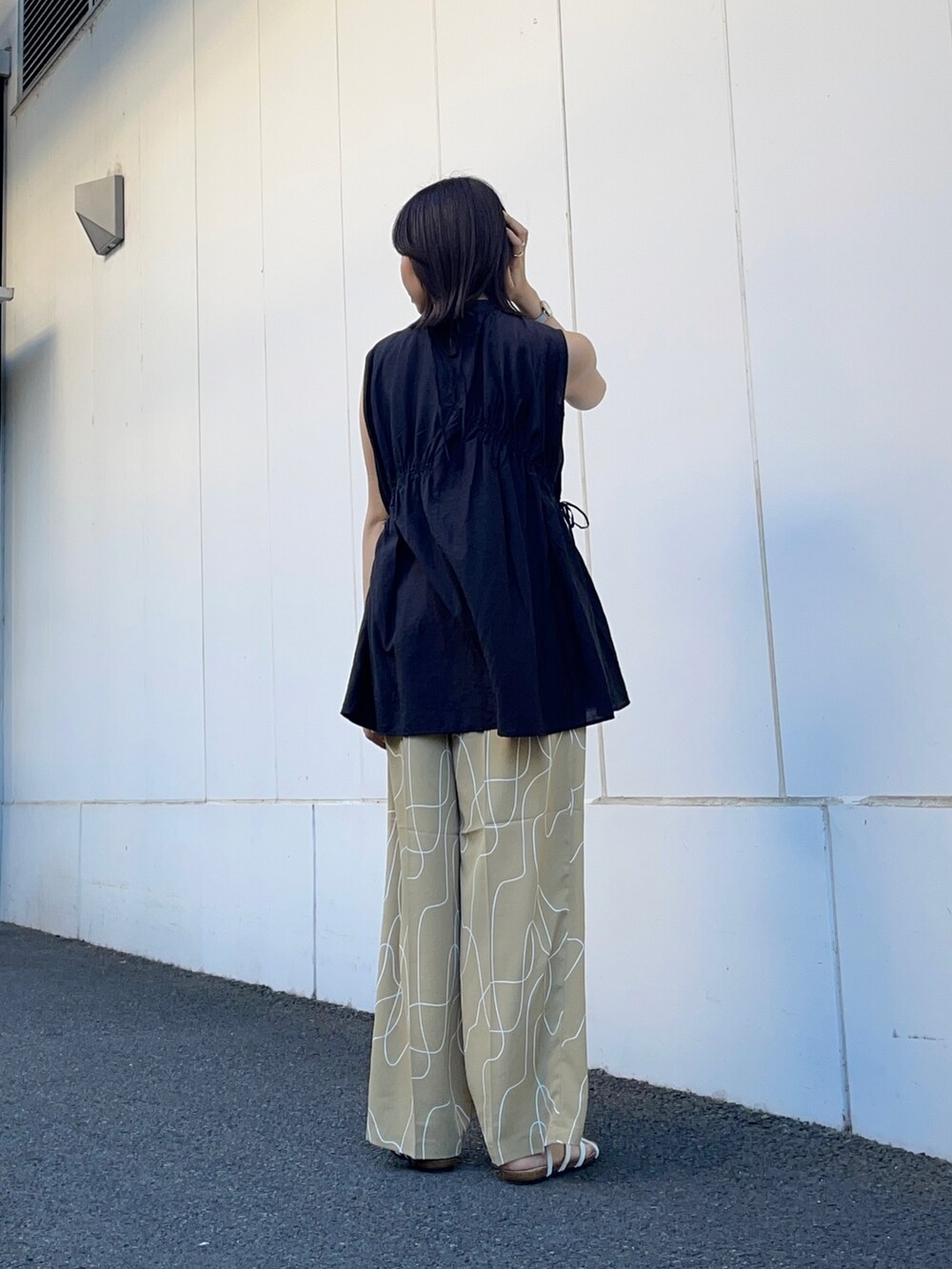 ブラック系のシャツ/ブラウス、ベージュ系のその他パンツ、ホワイト系のサンダルを着用したレディースの夏コーディネートの4枚目の写真
