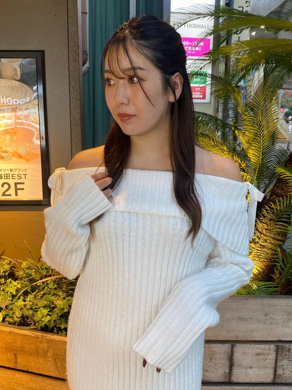 ホワイト系のワンピース、ブラック系のブーツを着用したレディースの冬コーディネートの2枚目の写真