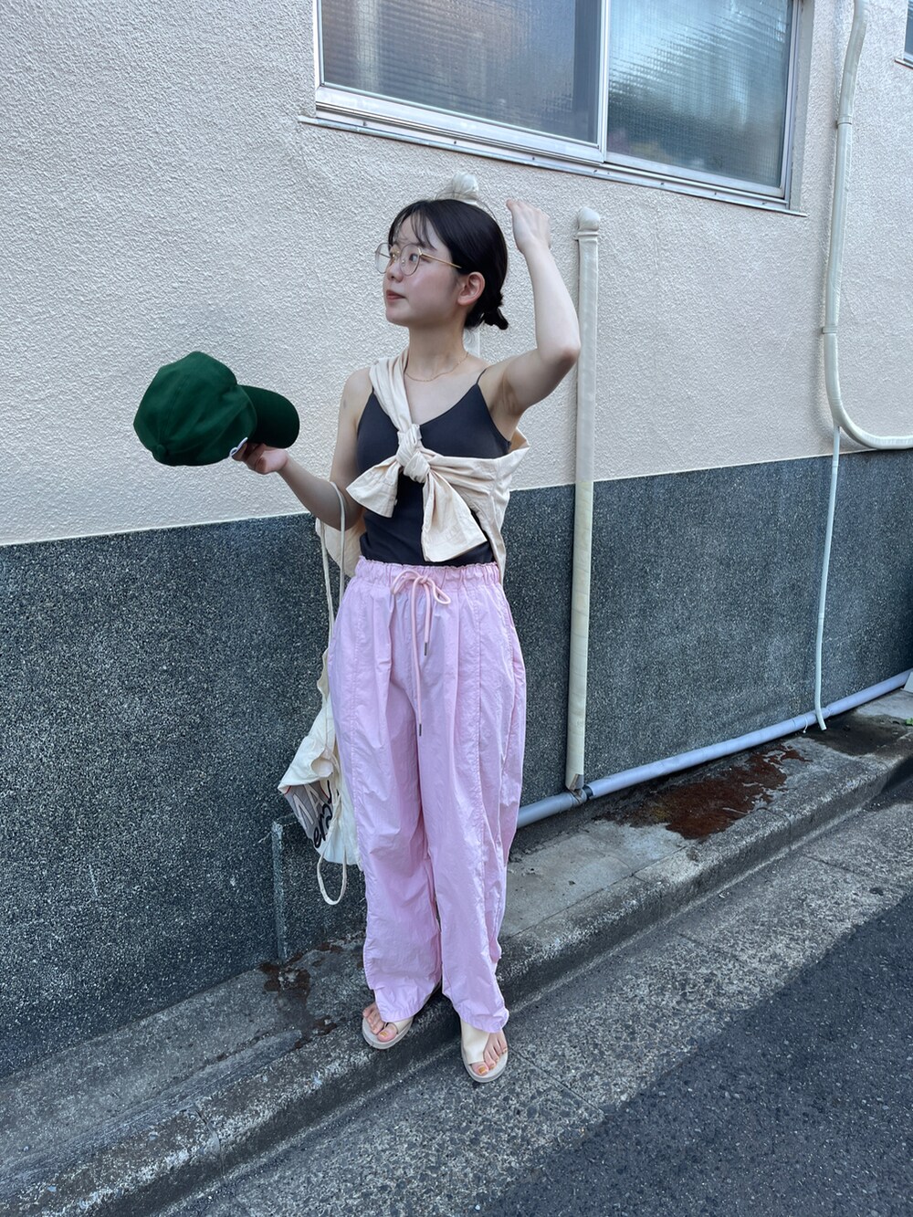 ピンク系のカーゴパンツ、グリーン系のキャップを着用したレディースの夏コーディネートの2枚目の写真