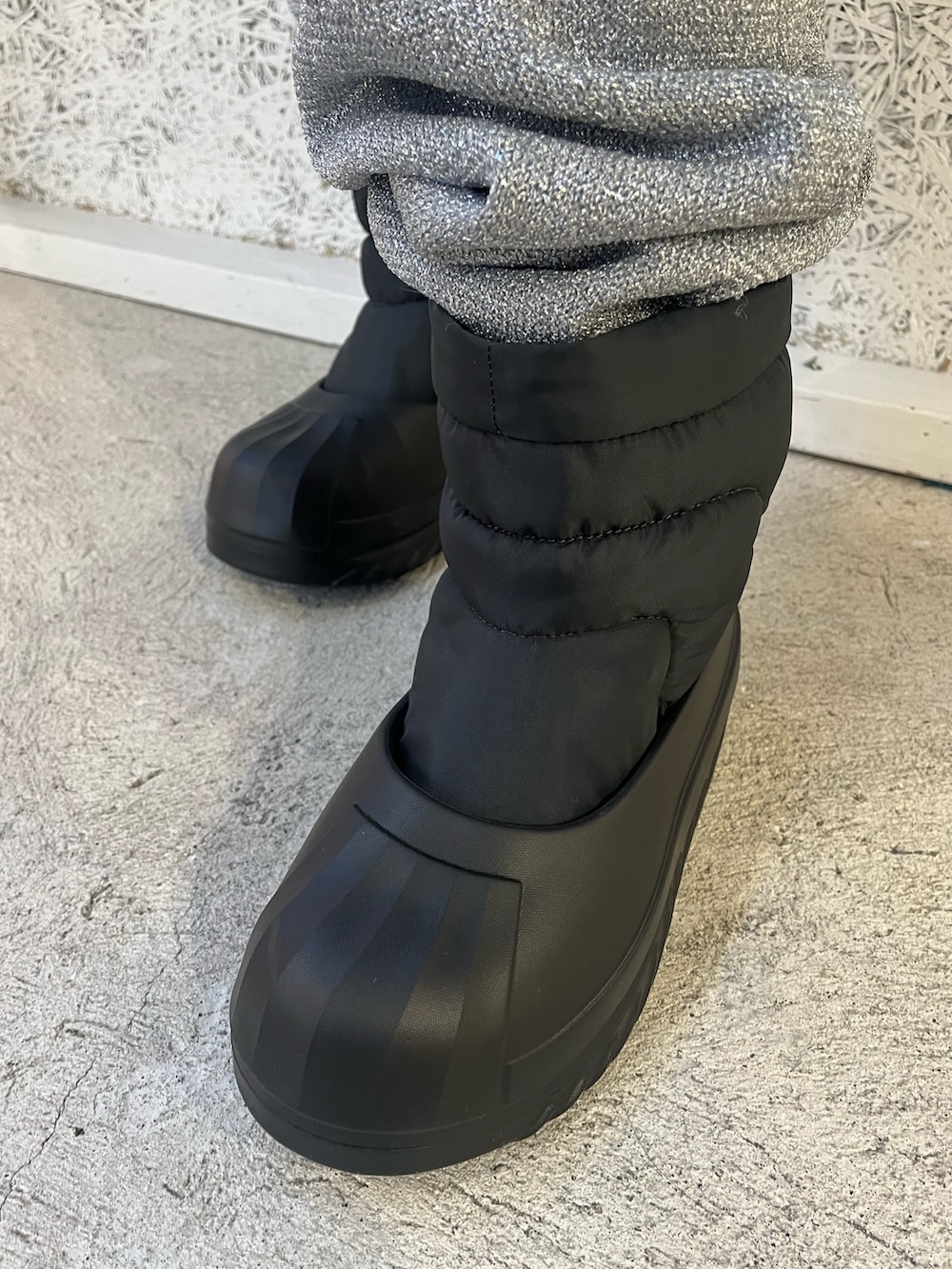 レッド系のジャージ、ブラック系のスニーカー、ブラック系のハットを着用したレディースの秋コーディネートの4枚目の写真