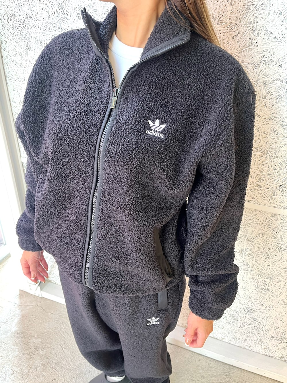 ブラック系のナイロンジャケット、ブラック系のその他パンツ、ブラック系のサンダルを着用したレディースの秋コーディネートの2枚目の写真