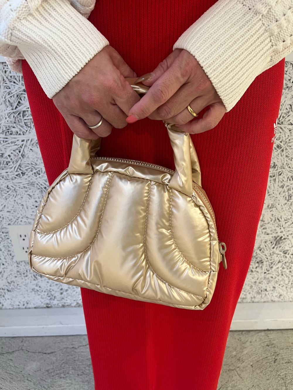 ホワイト系のニット/セーター、グレー系のシューズ、レッド系のスカートを着用したレディースの秋コーディネートの3枚目の写真