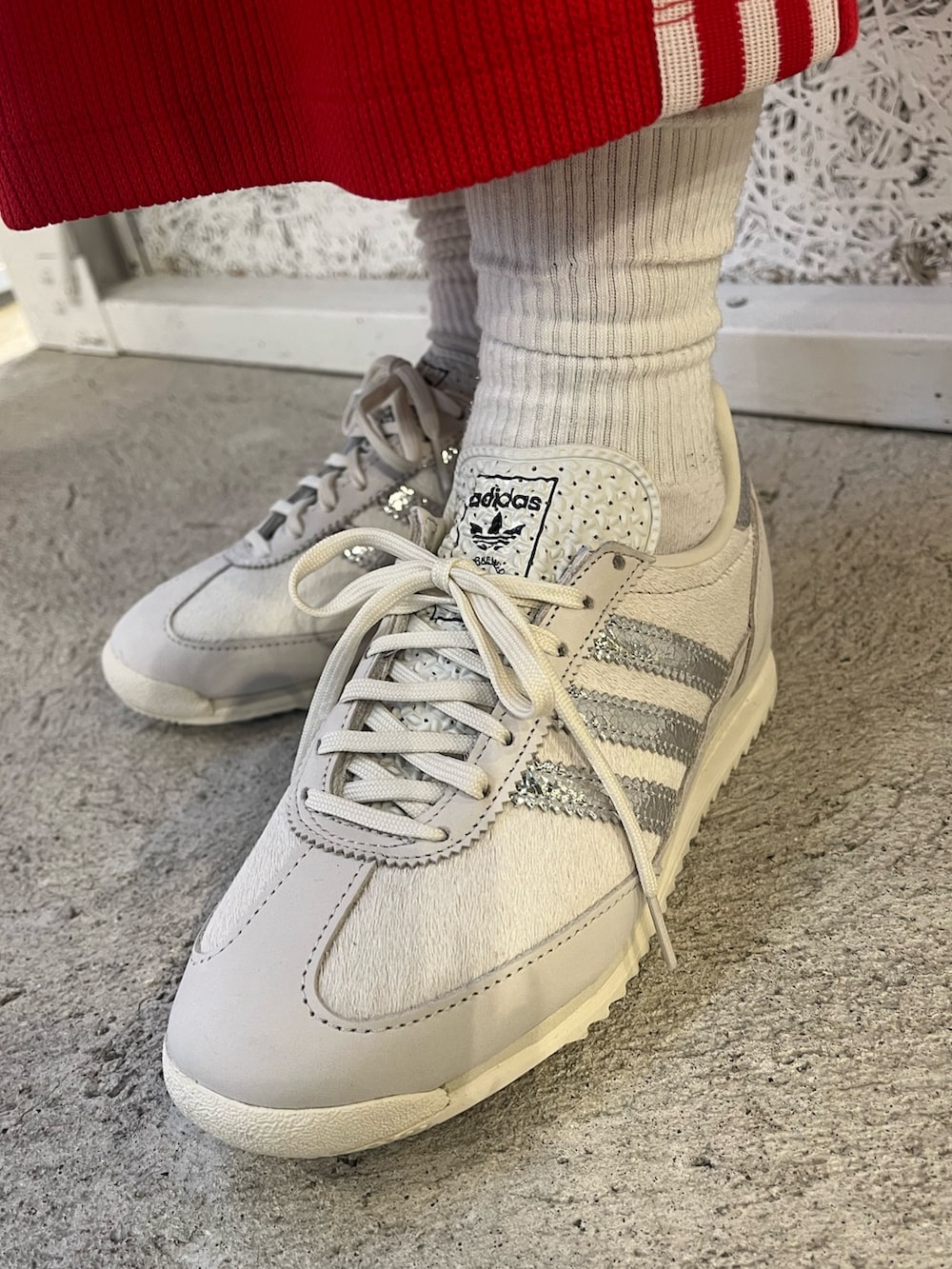 ホワイト系のニット/セーター、グレー系のシューズ、レッド系のスカートを着用したレディースの秋コーディネートの4枚目の写真