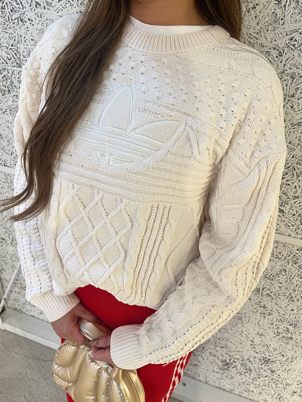 ホワイト系のニット/セーター、グレー系のシューズ、レッド系のスカートを着用したレディースの秋コーディネートの2枚目の写真