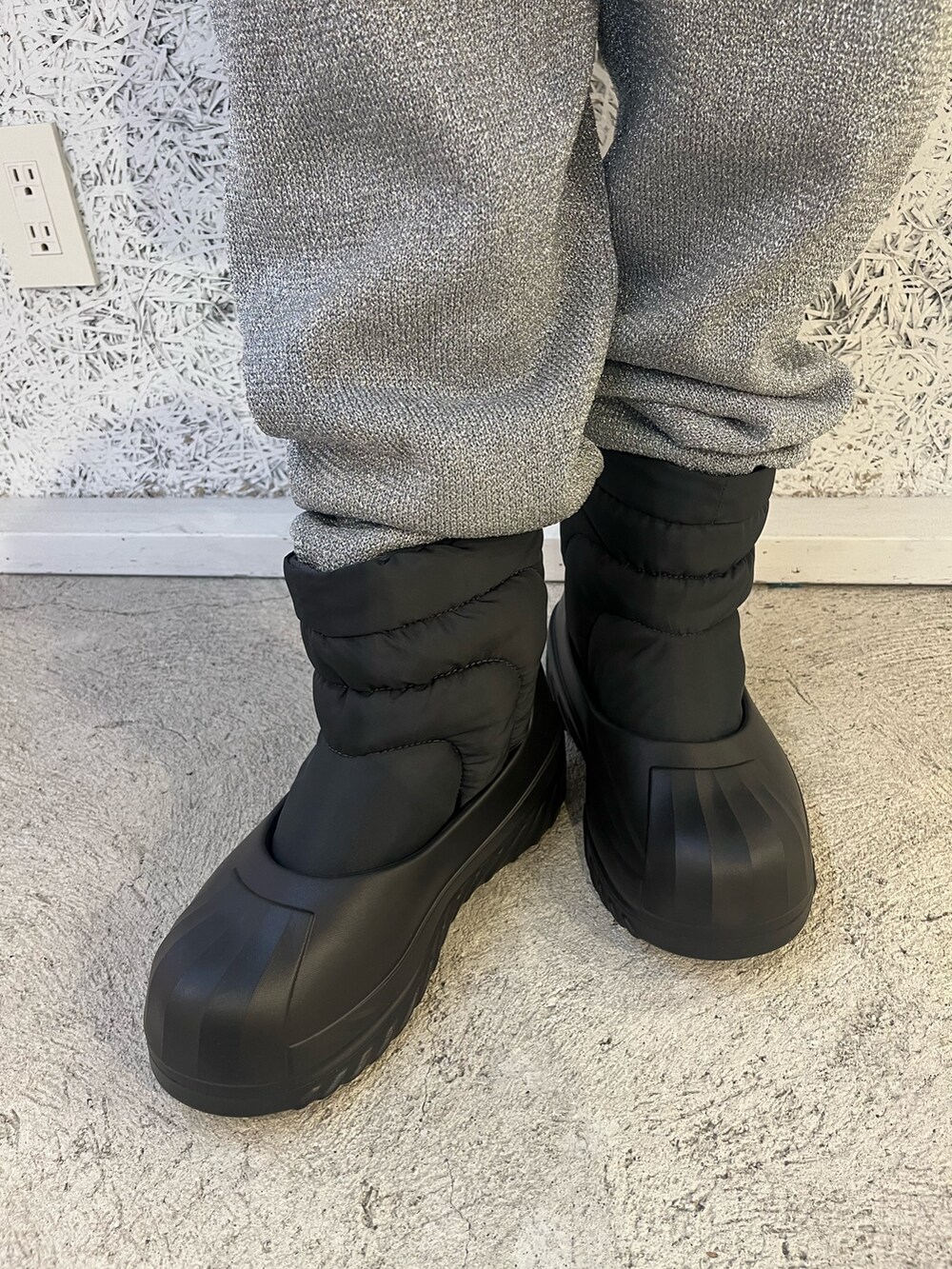 ブラック系のスニーカー、ブラック系のナイロンジャケット、ゴールド系のハンドバッグを着用したレディースの秋コーディネートの4枚目の写真