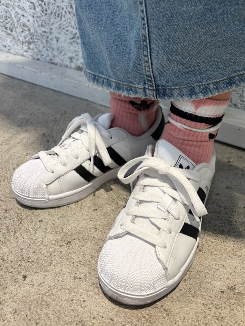 ホワイト系のスニーカー、ピンク系のTシャツ/カットソー、シルバー系のハンドバッグを着用したレディースの春コーディネートの3枚目の写真