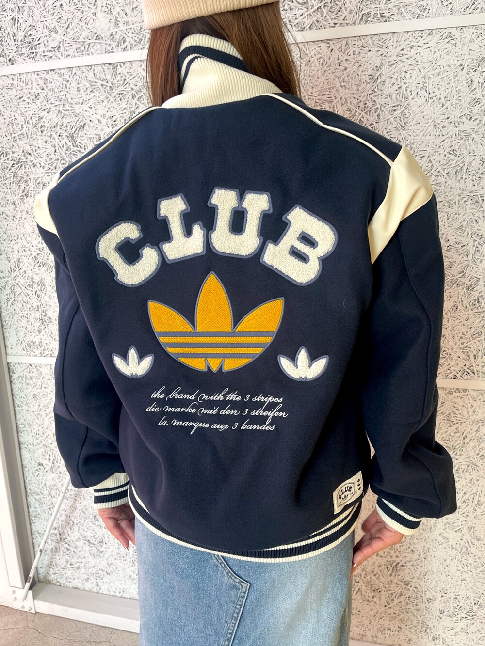 ブルー系のブルゾン、ホワイト系のシューズ、ホワイト系のニットキャップ/ビーニーを着用したレディースの秋コーディネートの3枚目の写真