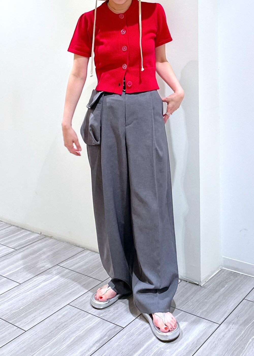 シルバー系のサンダル、グレー系のスラックス、レッド系のカーディガン/ボレロを着用したレディースの夏コーディネートの3枚目の写真
