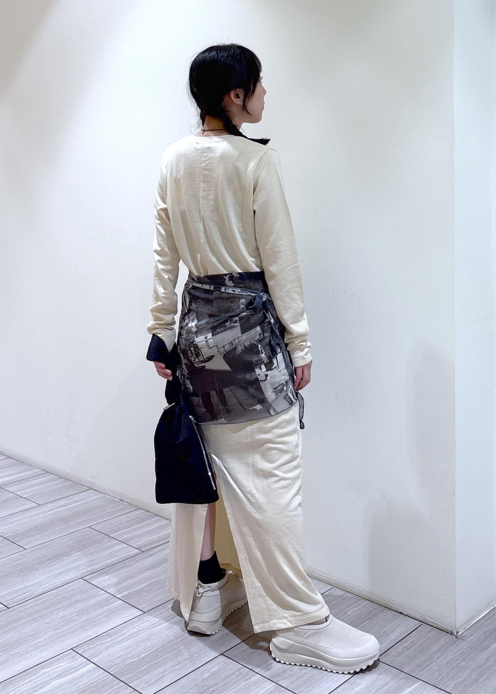 ブラック系のハンドバッグ、ベージュ系のスニーカー、ホワイト系のワンピースを着用したレディースの夏コーディネートの4枚目の写真