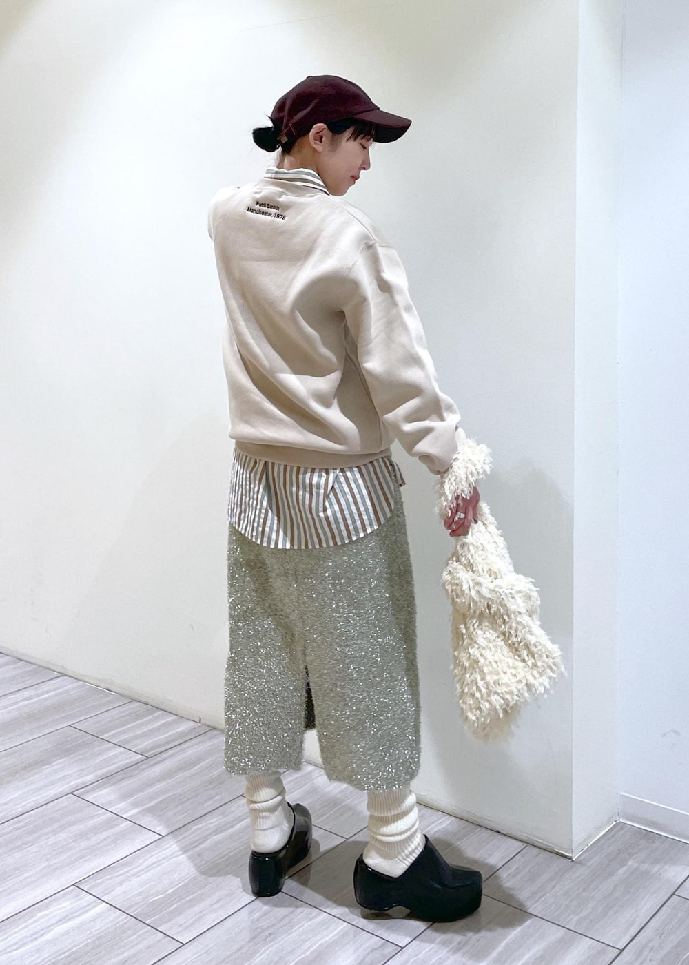 ブラック系のその他シューズ、ホワイト系のハンドバッグ、ホワイト系のソックス/靴下を着用したレディースの冬コーディネートの3枚目の写真