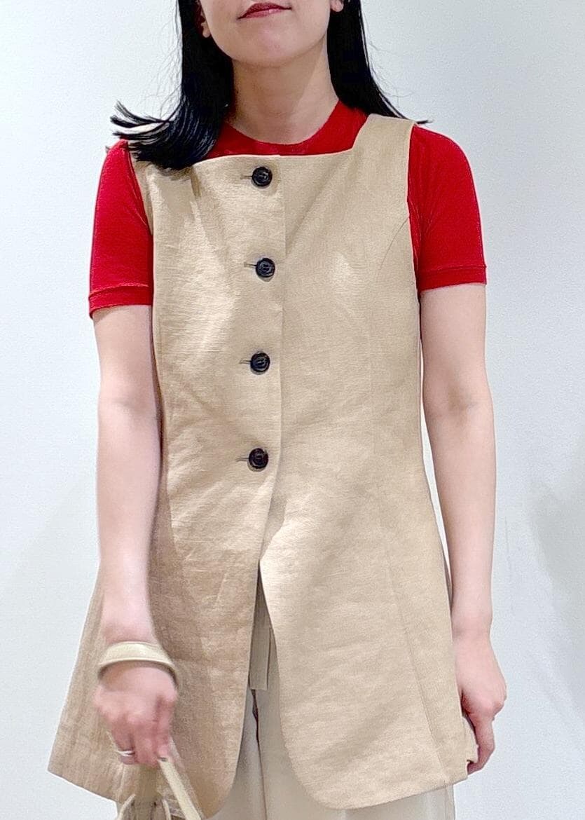 ベージュ系のショルダーバッグ、ホワイト系のスラックス、ベージュ系のベストを着用したレディースの春コーディネートの5枚目の写真