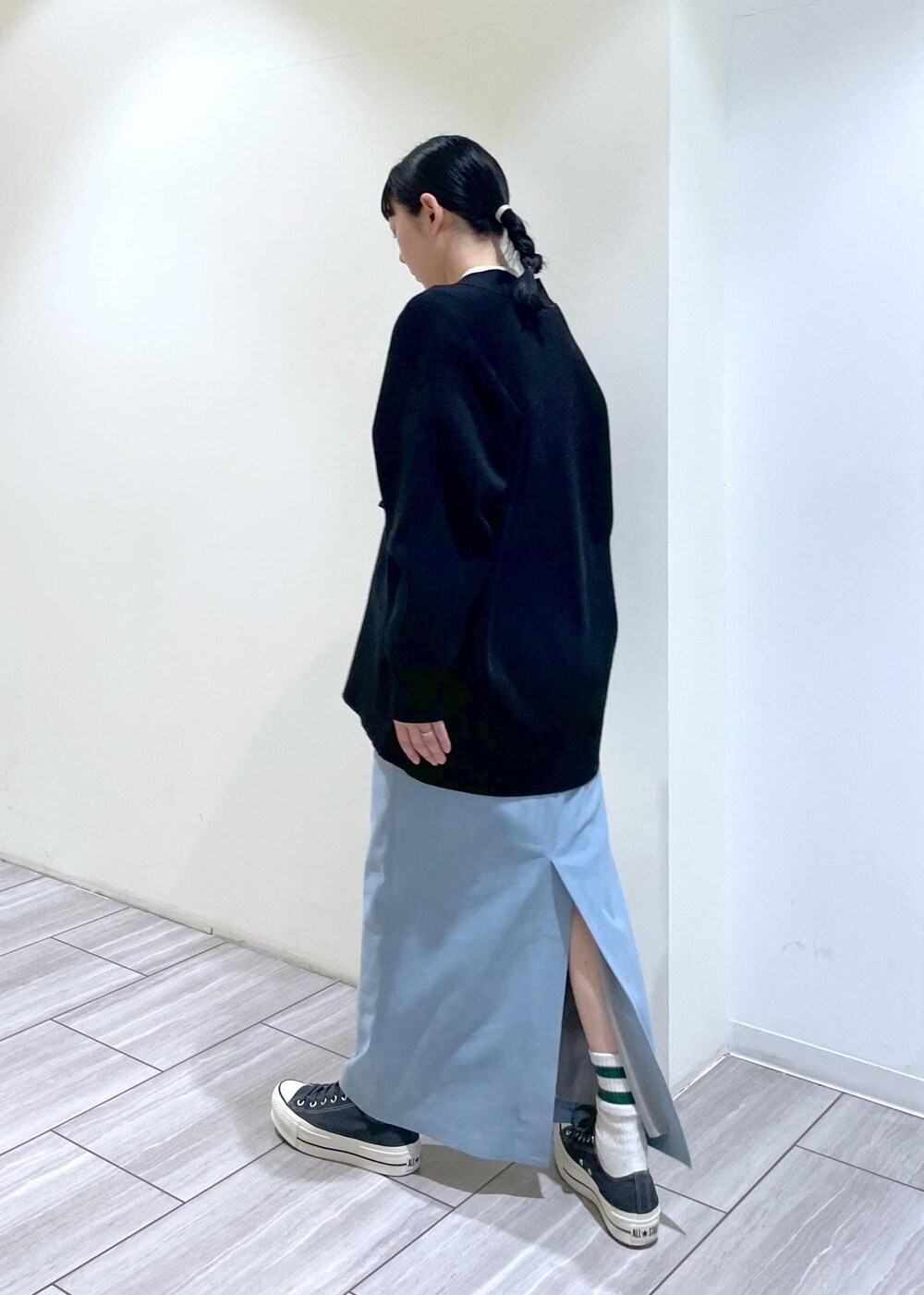 ホワイト系のボストンバッグ、ブルー系のスカート、ブラック系のカーディガン/ボレロを着用したレディースの冬コーディネートの4枚目の写真