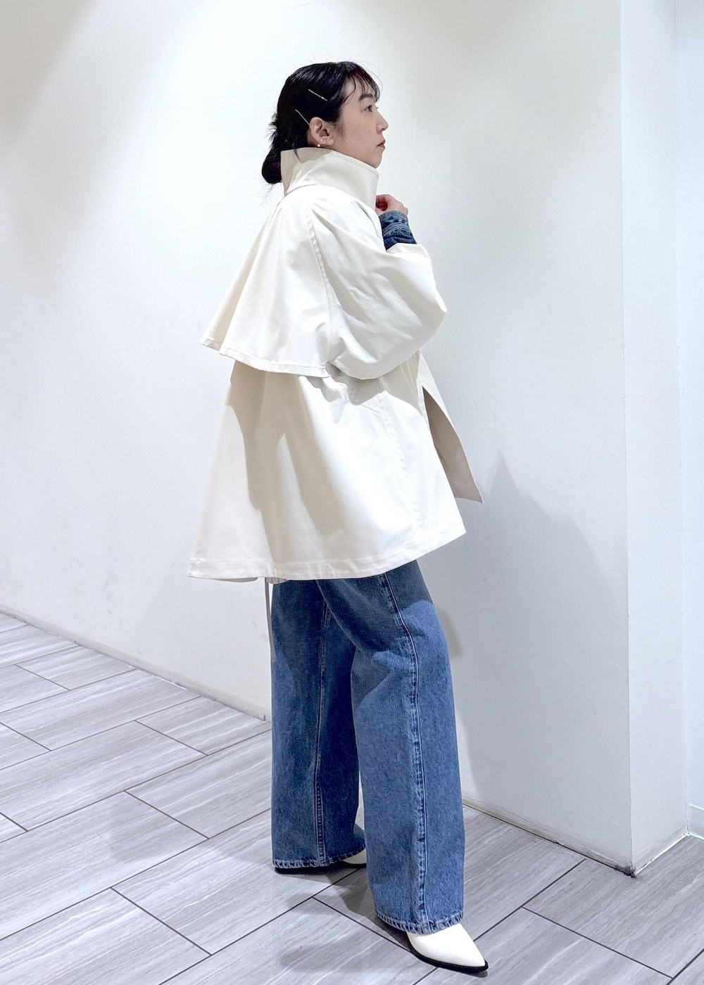 ホワイト系のパンプス、ブラウン系のボストンバッグ、ホワイト系のトレンチコートを着用したレディースの冬コーディネートの3枚目の写真