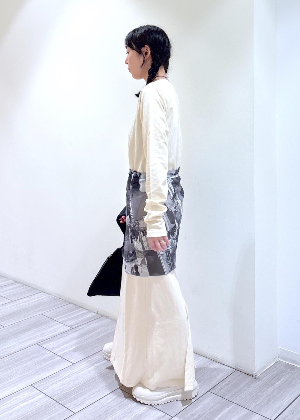 ブラック系のハンドバッグ、ベージュ系のスニーカー、ホワイト系のワンピースを着用したレディースの夏コーディネートの5枚目の写真