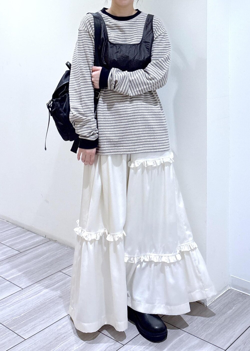 ブラック系のブーツ、ホワイト系のスカート、ホワイト系のTシャツ/カットソーを着用したレディースの冬コーディネートの5枚目の写真