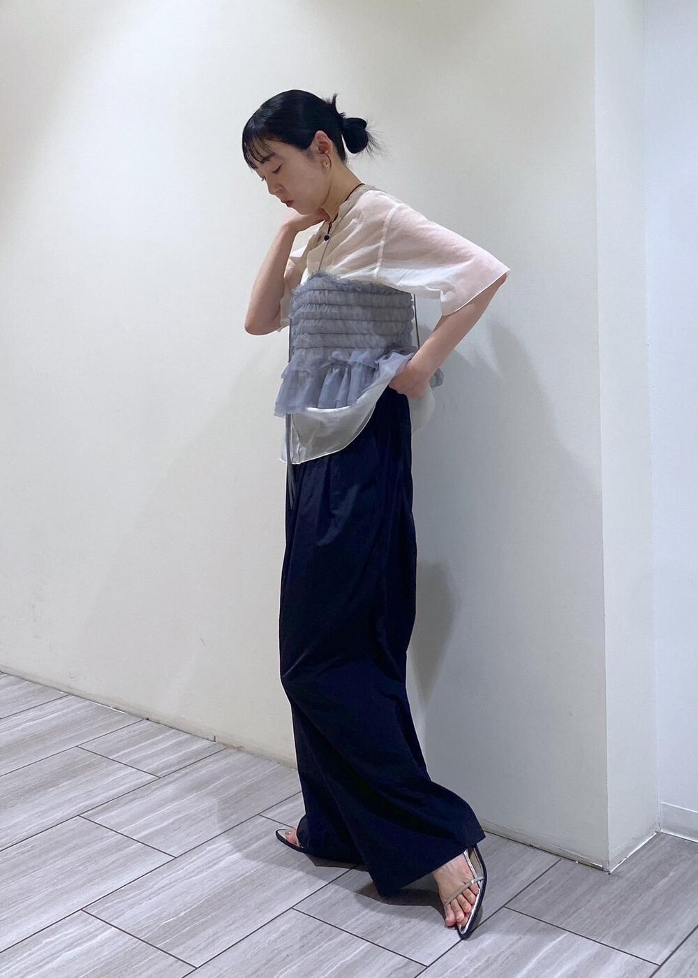 シルバー系のハンドバッグ、シルバー系のサンダル、ホワイト系のTシャツ/カットソーを着用したレディースの夏コーディネートの5枚目の写真