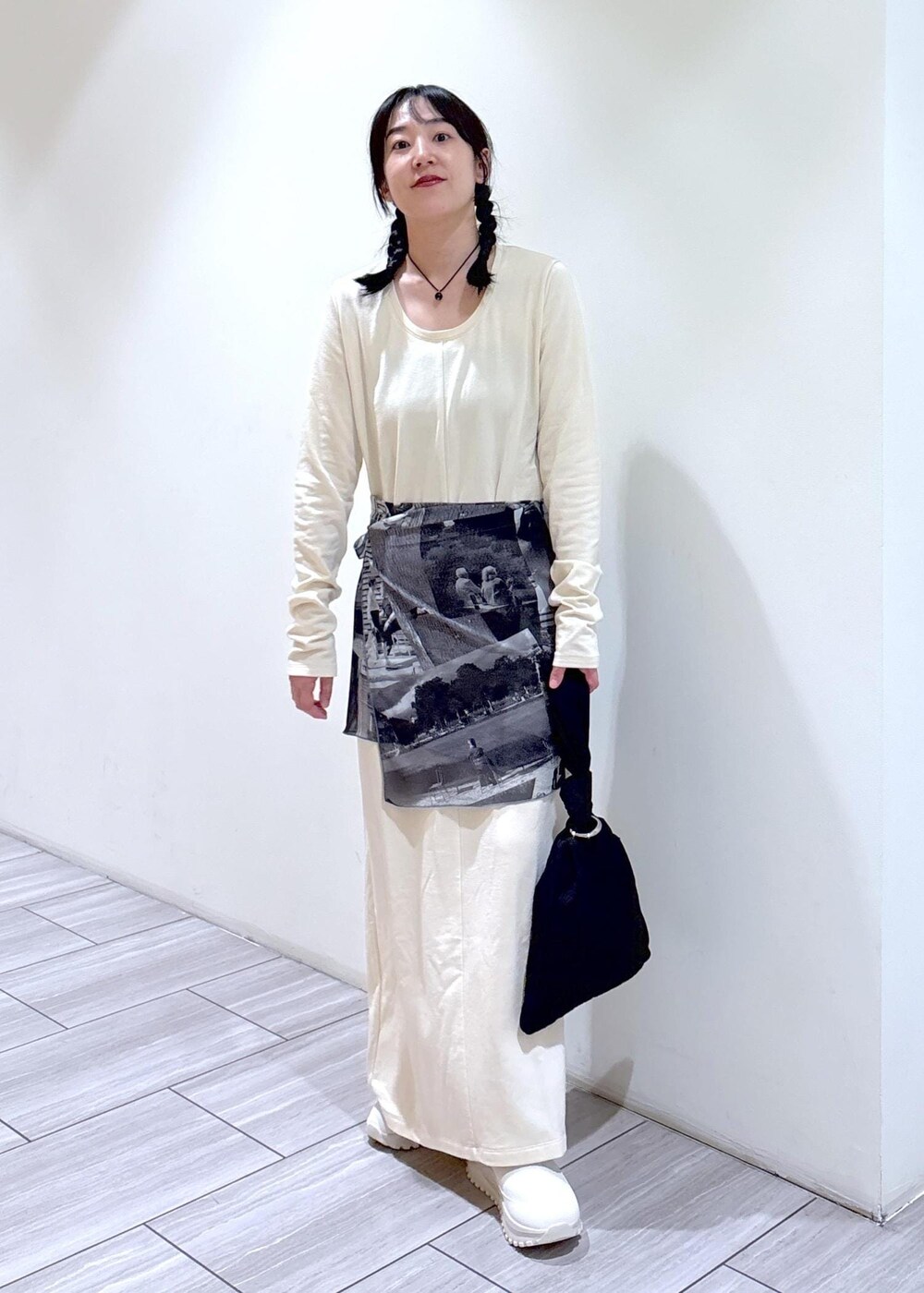 ブラック系のハンドバッグ、ベージュ系のスニーカー、ホワイト系のワンピースを着用したレディースの夏コーディネートの6枚目の写真