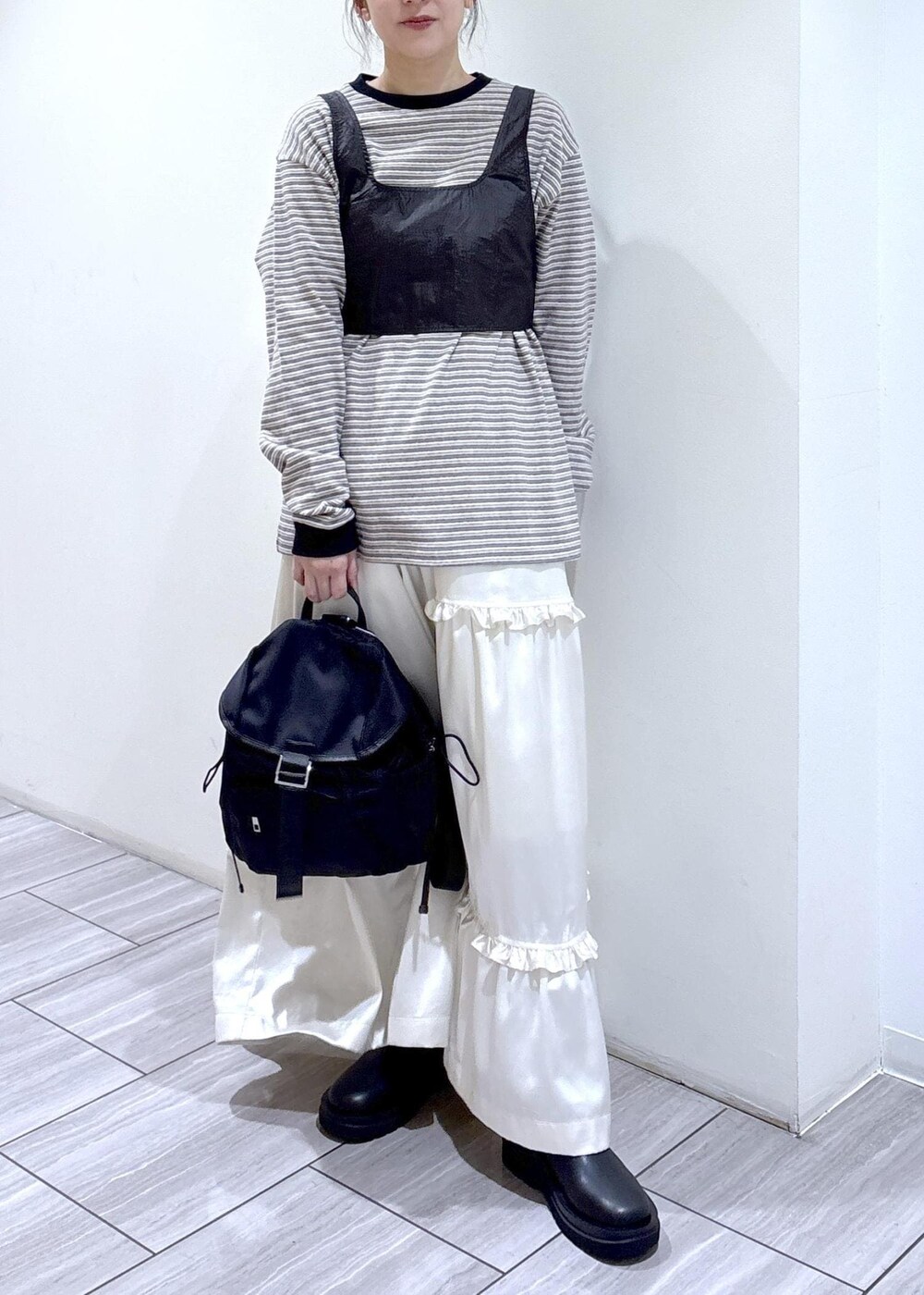 ブラック系のブーツ、ホワイト系のスカート、ホワイト系のTシャツ/カットソーを着用したレディースの冬コーディネートの4枚目の写真