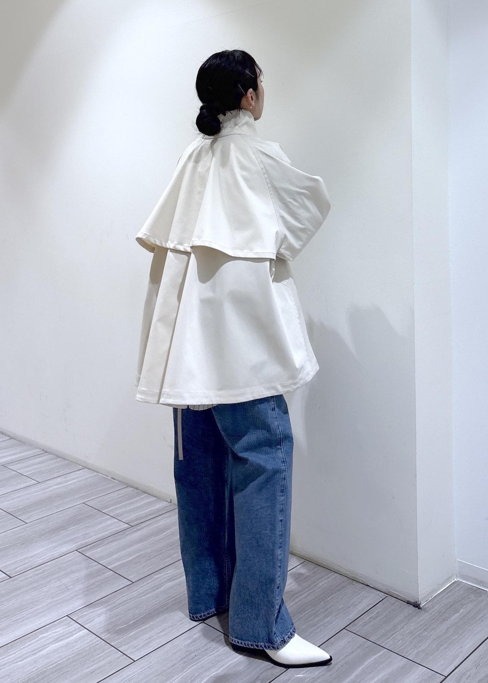 ホワイト系のパンプス、ブラウン系のボストンバッグ、ホワイト系のトレンチコートを着用したレディースの冬コーディネートの4枚目の写真