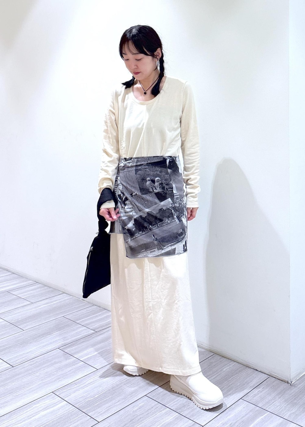 ブラック系のハンドバッグ、ベージュ系のスニーカー、ホワイト系のワンピースを着用したレディースの夏コーディネートの2枚目の写真