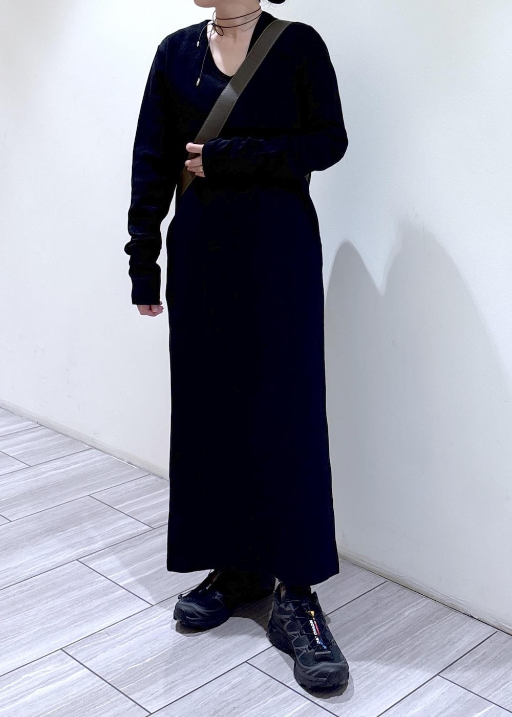 ブラック系のワンピース、ブラック系のショルダーバッグ、ブラック系のスニーカーを着用したレディースの秋コーディネートの5枚目の写真