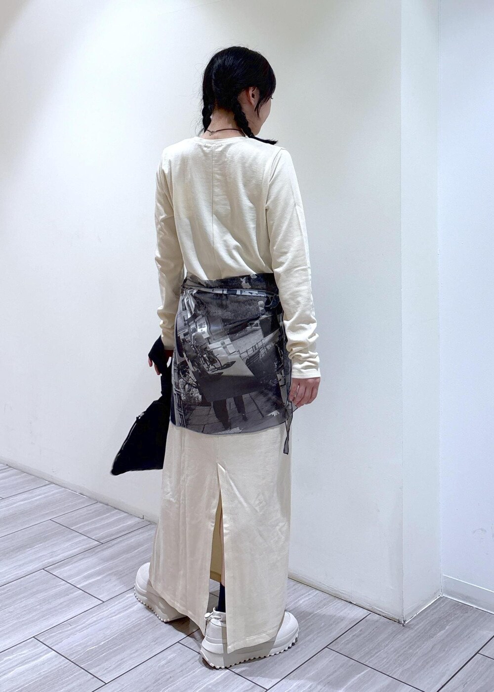 ブラック系のハンドバッグ、ベージュ系のスニーカー、ホワイト系のワンピースを着用したレディースの夏コーディネートの3枚目の写真