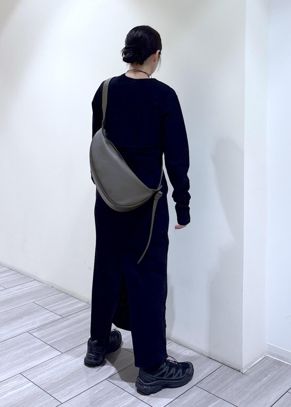 ブラック系のワンピース、ブラック系のショルダーバッグ、ブラック系のスニーカーを着用したレディースの秋コーディネートの3枚目の写真