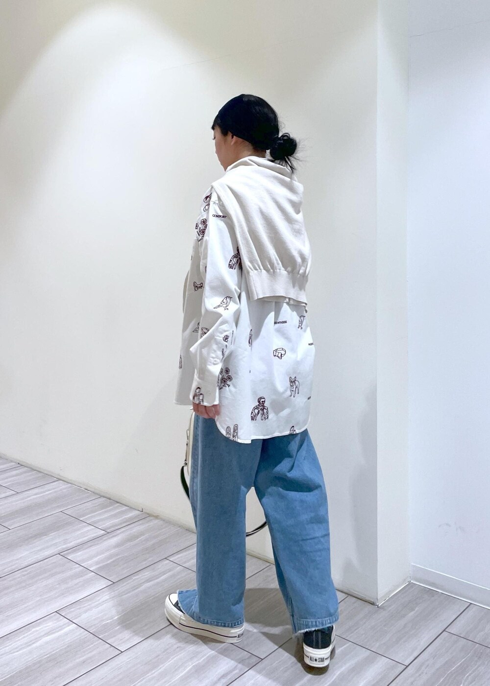 ブルー系のデニムパンツ、ホワイト系のボストンバッグ、ベージュ系のカーディガン/ボレロを着用したレディースの冬コーディネートの4枚目の写真