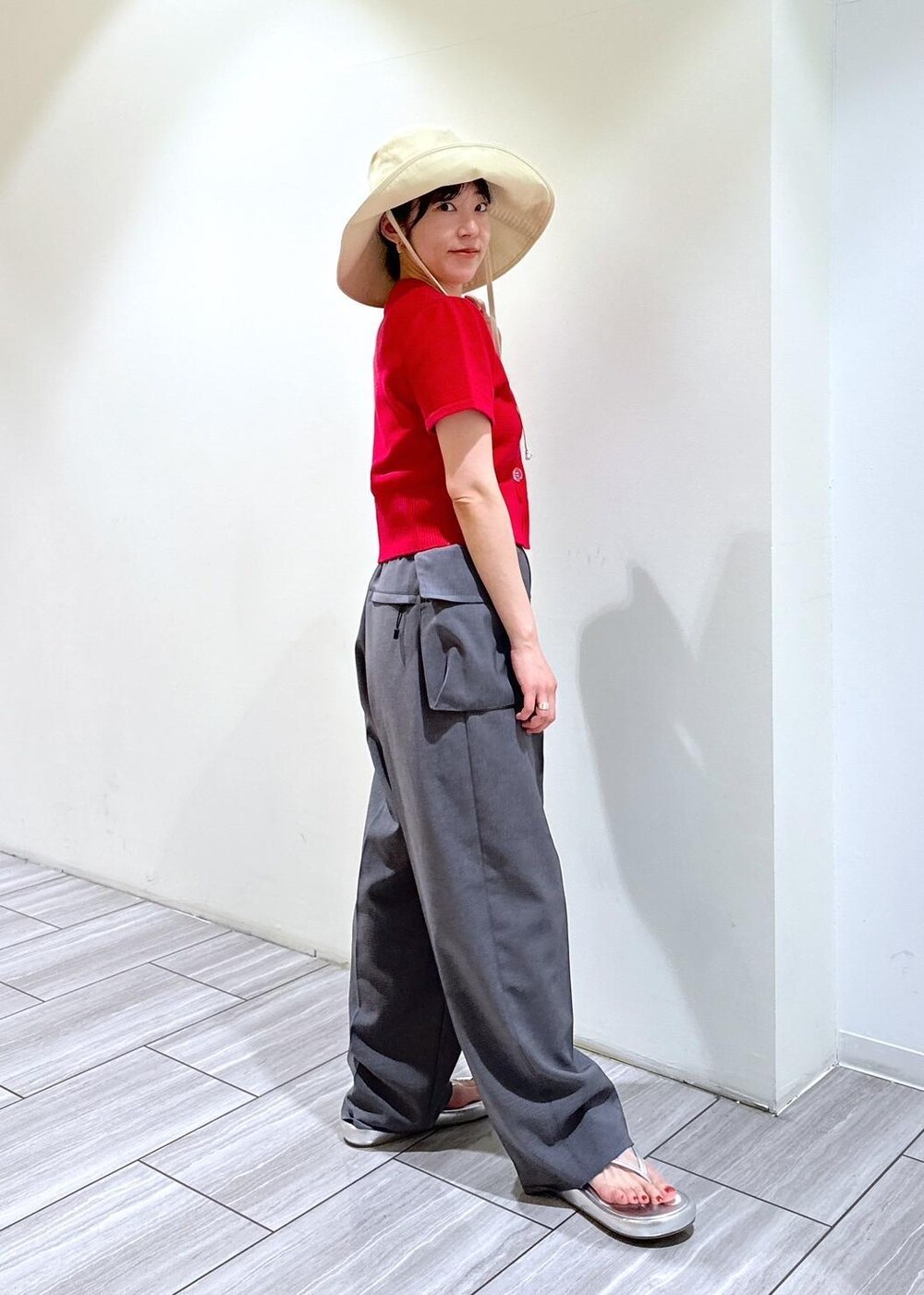 シルバー系のサンダル、グレー系のスラックス、レッド系のカーディガン/ボレロを着用したレディースの夏コーディネートの4枚目の写真
