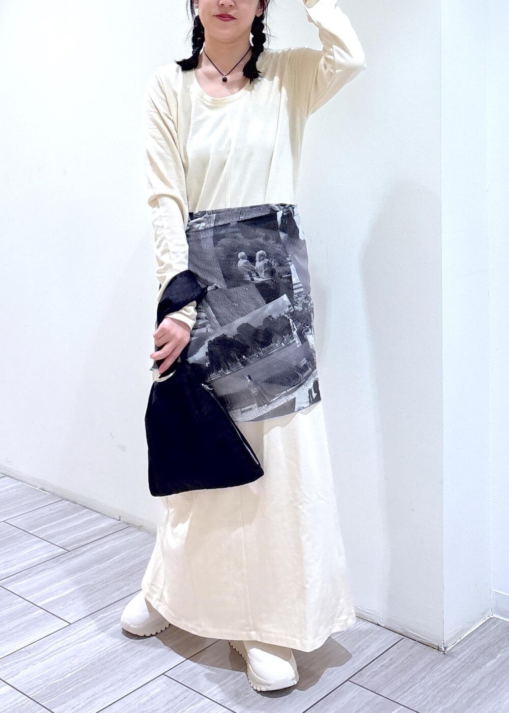 ブラック系のハンドバッグ、ベージュ系のスニーカー、ホワイト系のワンピースを着用したレディースの夏コーディネートの7枚目の写真