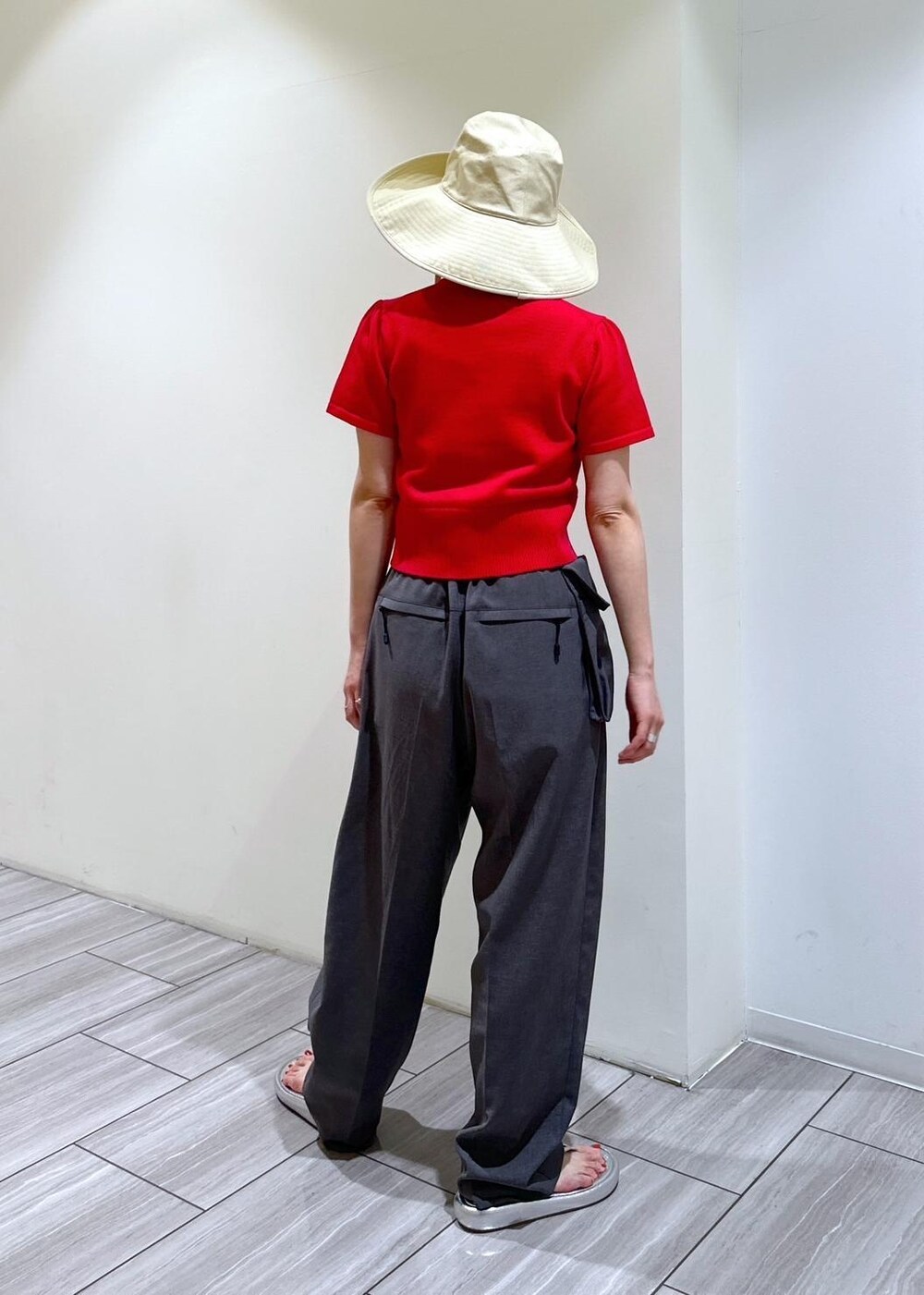 シルバー系のサンダル、グレー系のスラックス、レッド系のカーディガン/ボレロを着用したレディースの夏コーディネートの2枚目の写真