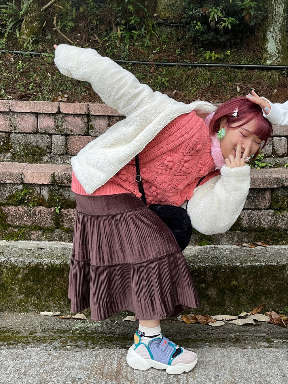 ブラック系のショルダーバッグ、ピンク系のニット/セーターを着用したレディースの冬コーディネートの2枚目の写真