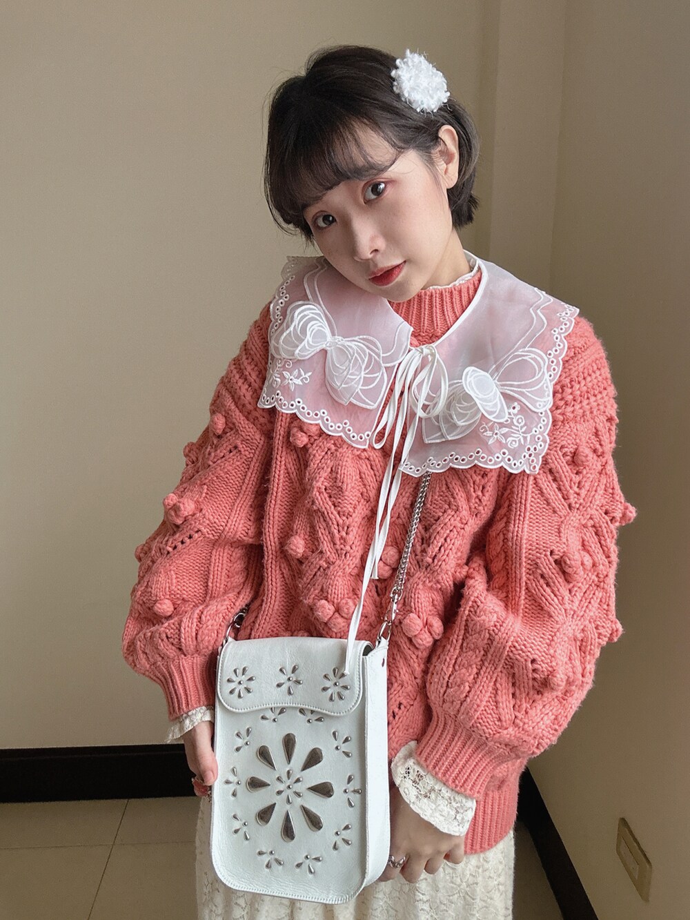 ホワイト系のショルダーバッグ、ピンク系のニット/セーター、ピンク系のバレエシューズを着用したレディースの冬コーディネートの2枚目の写真