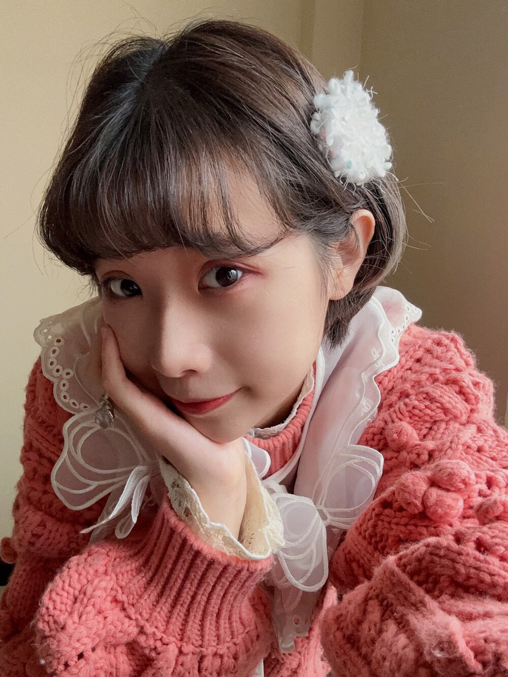 ホワイト系のショルダーバッグ、ピンク系のニット/セーター、ピンク系のバレエシューズを着用したレディースの冬コーディネートの3枚目の写真