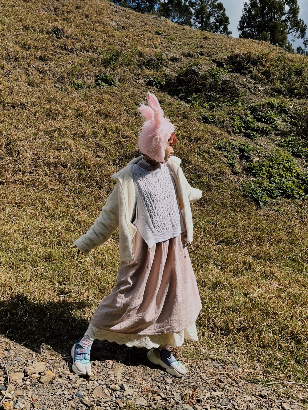 ブラック系のショルダーバッグ、ホワイト系のニット/セーター、パープル系のスニーカーを着用したレディースの冬コーディネートの2枚目の写真