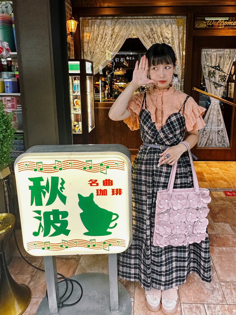 ピンク系のショルダーバッグ、パープル系のジャンパースカート、オレンジ系のシャツ/ブラウスを着用したレディースの夏コーディネートの3枚目の写真