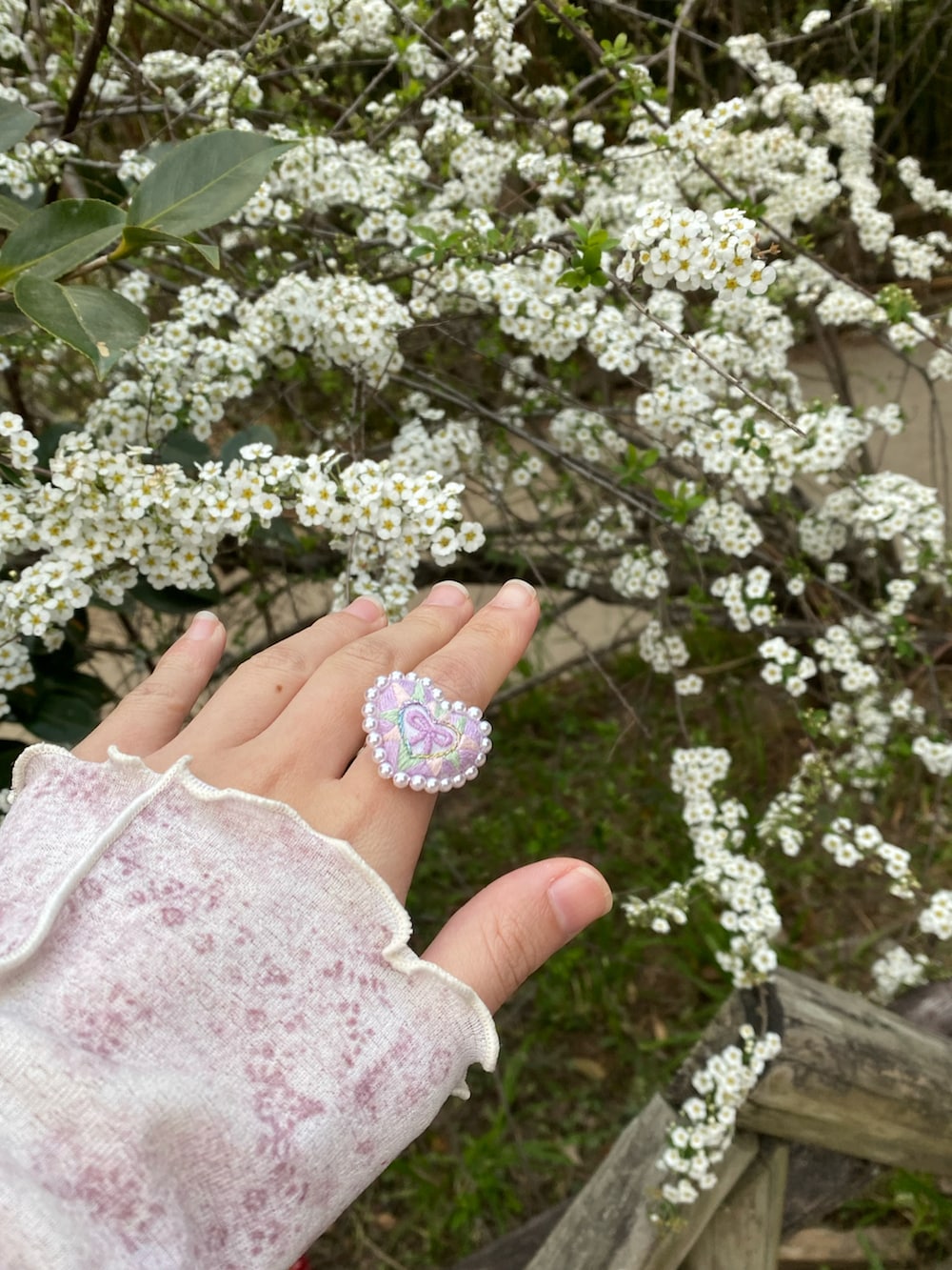 ピンク系のスニーカー、パープル系のワンピース、ホワイト系のブルゾンを着用したレディースの春コーディネートの3枚目の写真