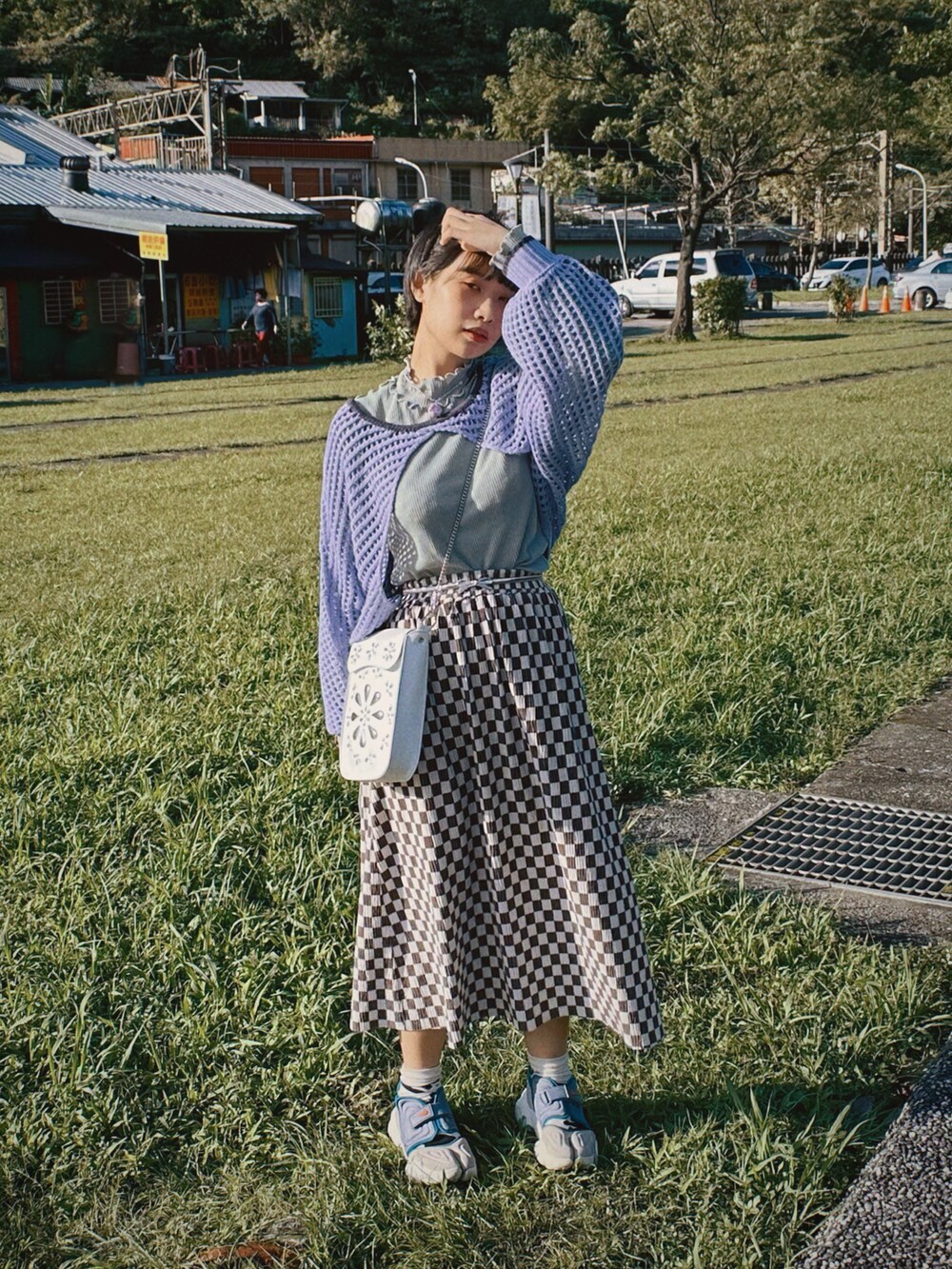 ホワイト系のショルダーバッグ、パープル系のスニーカー、グリーン系のニット/セーターを着用したレディースの秋コーディネートの2枚目の写真