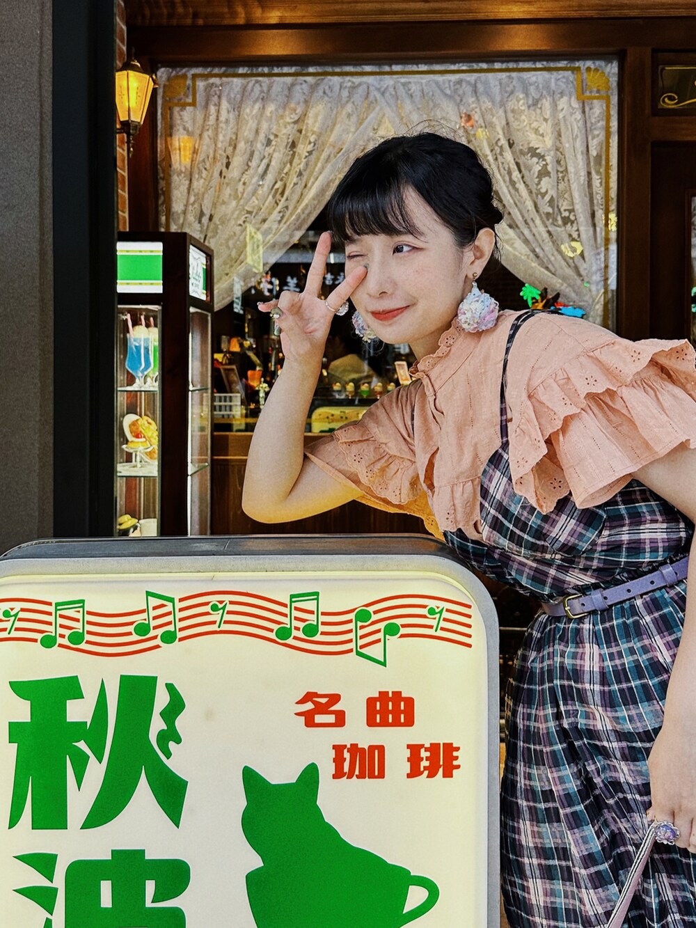 ピンク系のショルダーバッグ、パープル系のジャンパースカート、オレンジ系のシャツ/ブラウスを着用したレディースの夏コーディネートの5枚目の写真