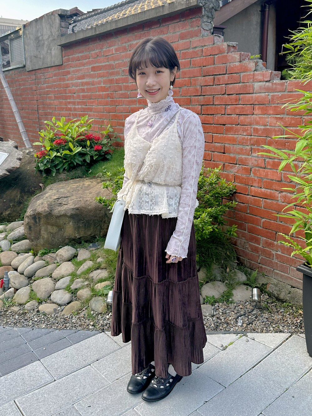 ピンク系のニット/セーター、ホワイト系のショルダーバッグ、ブラック系のサンダルを着用したレディースの秋コーディネートの2枚目の写真